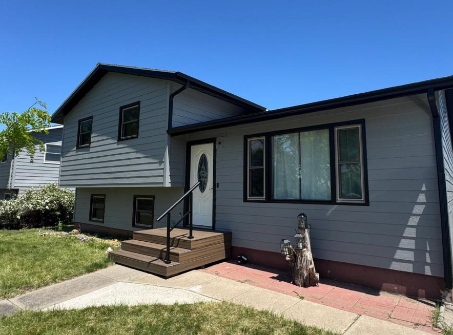 new-trim-and-gutters Freshly installed black exterior trim and seamless gutters providing a modern aesthetic and enhanced water protection for a home