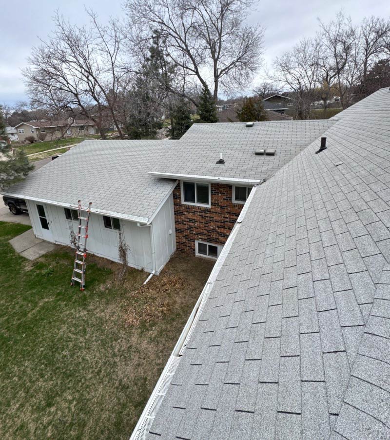 old-roof Top-down view of a light gray residential asphalt shingle roof, showcasing a roof replacement project