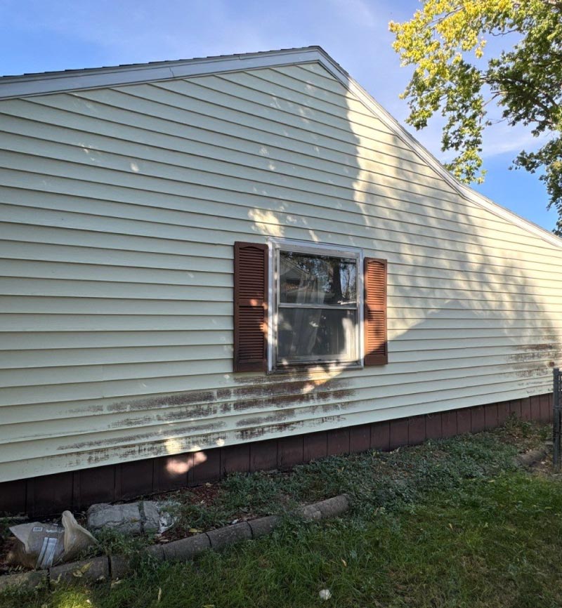 old-window Example of an older, weathered residential window with sun-damaged siding, illustrating the need for professional replacement