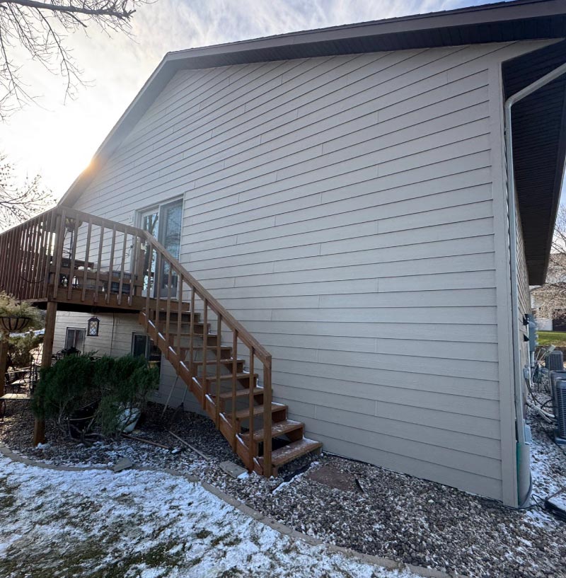 siding-project "Wide view of a professional siding renovation project currently in progress on a suburban residential property